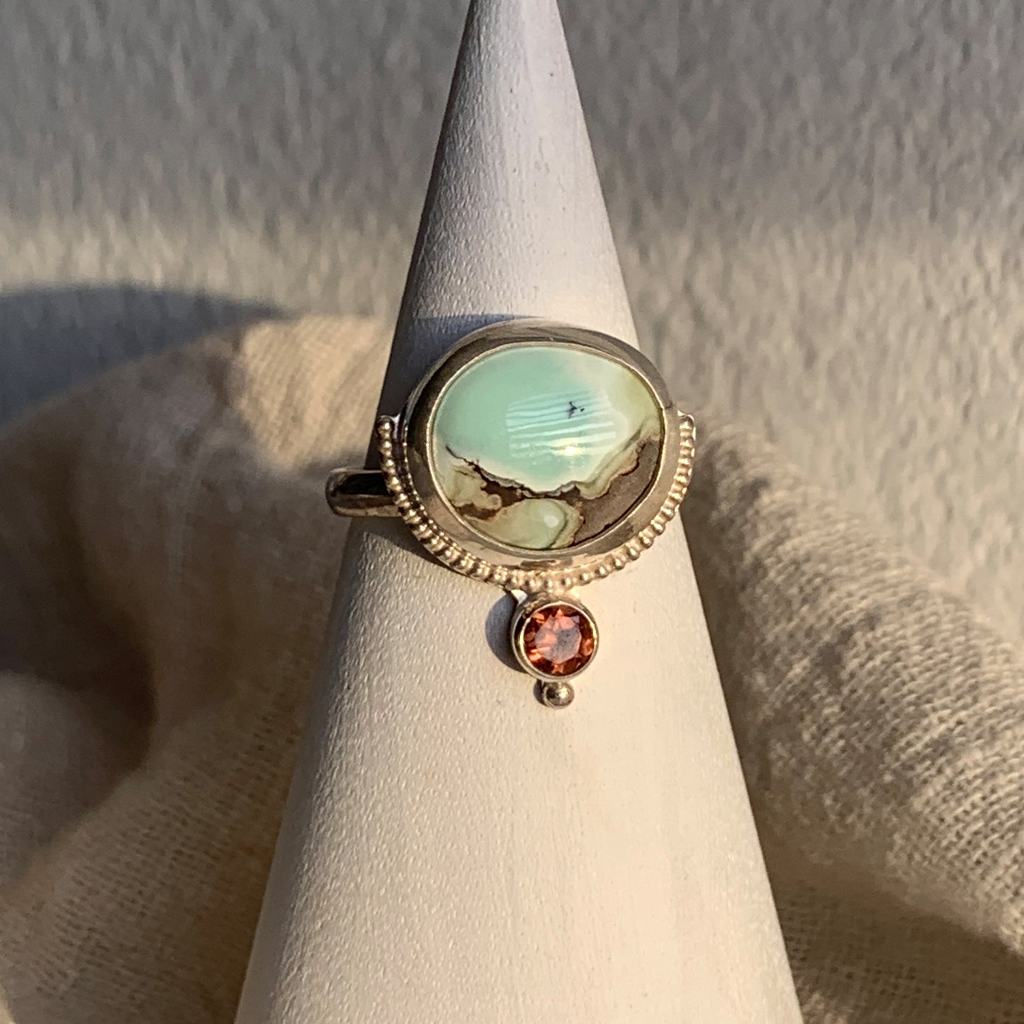 Hand fabricated, two stone, moderate statement ring featuring a stunning Poseidon Variscite cabochon paired with a bright, faceted pink/peach Tourmaline and silver raindrop and beaded wire details.